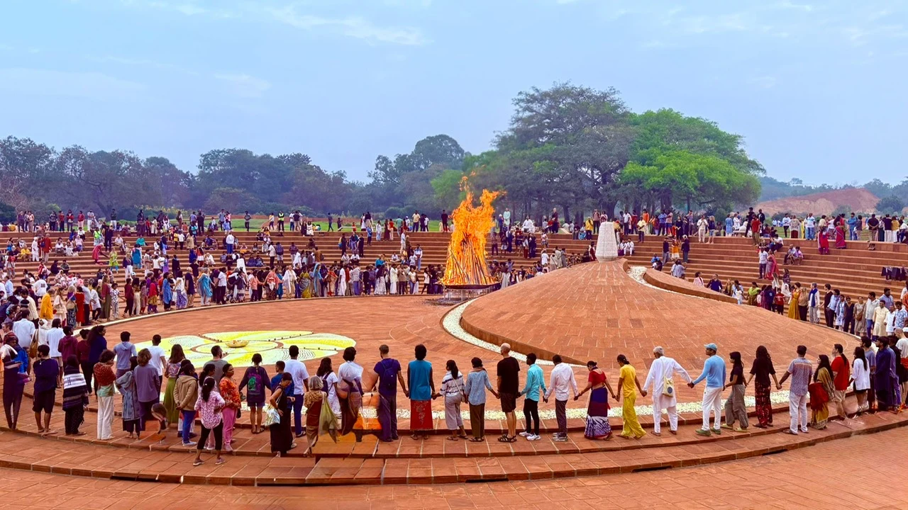 Gathering at a cultural ceremony with people joining hands around a fire