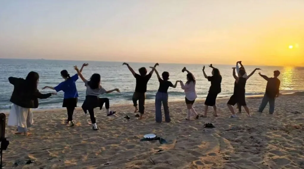 Sanya NCC members dancing on the beach at sunset on Hainan Island