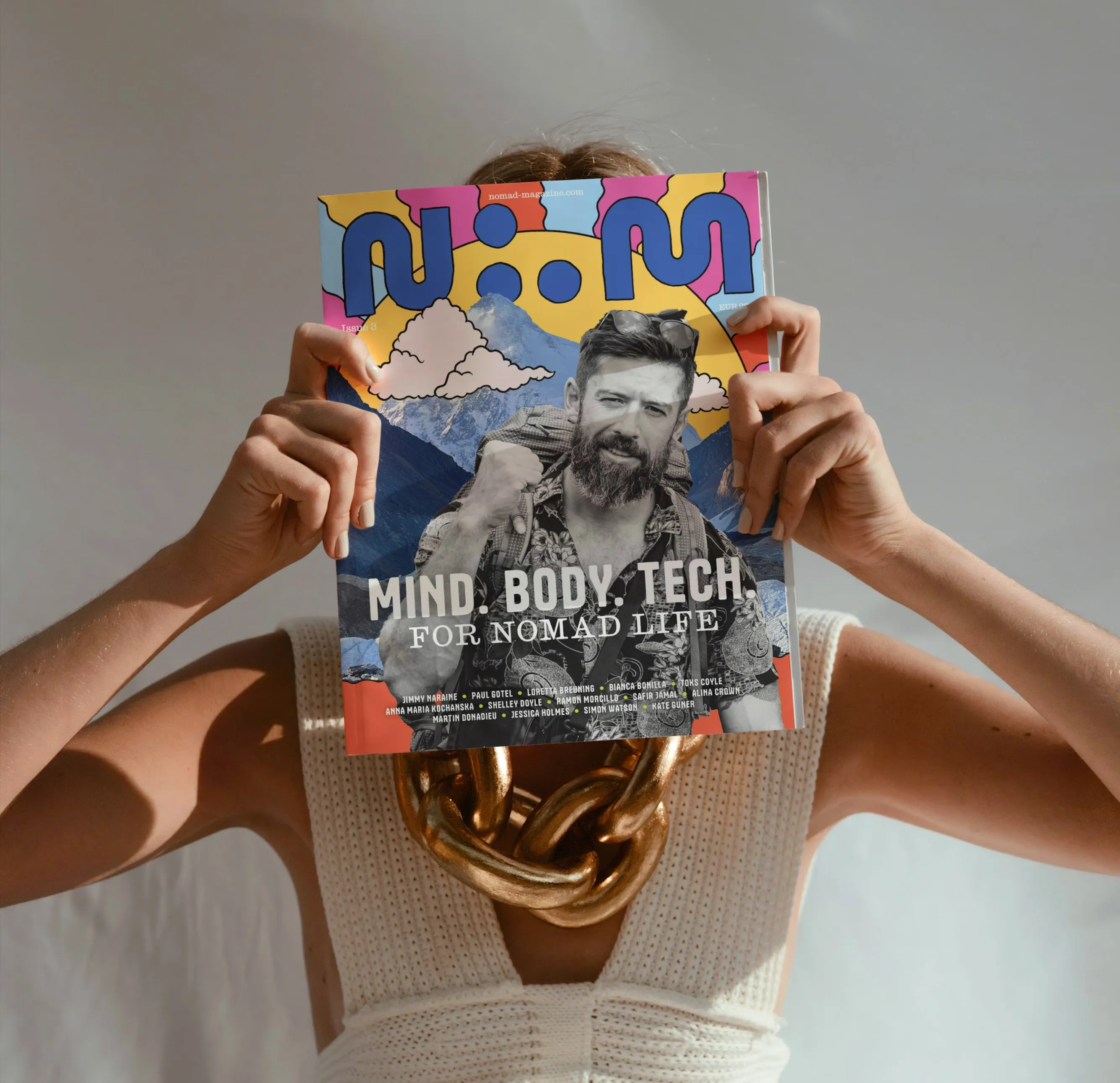 a woman holding a magazine covering her face. Nomad Magazine - the first independent publication about digital nomad trend