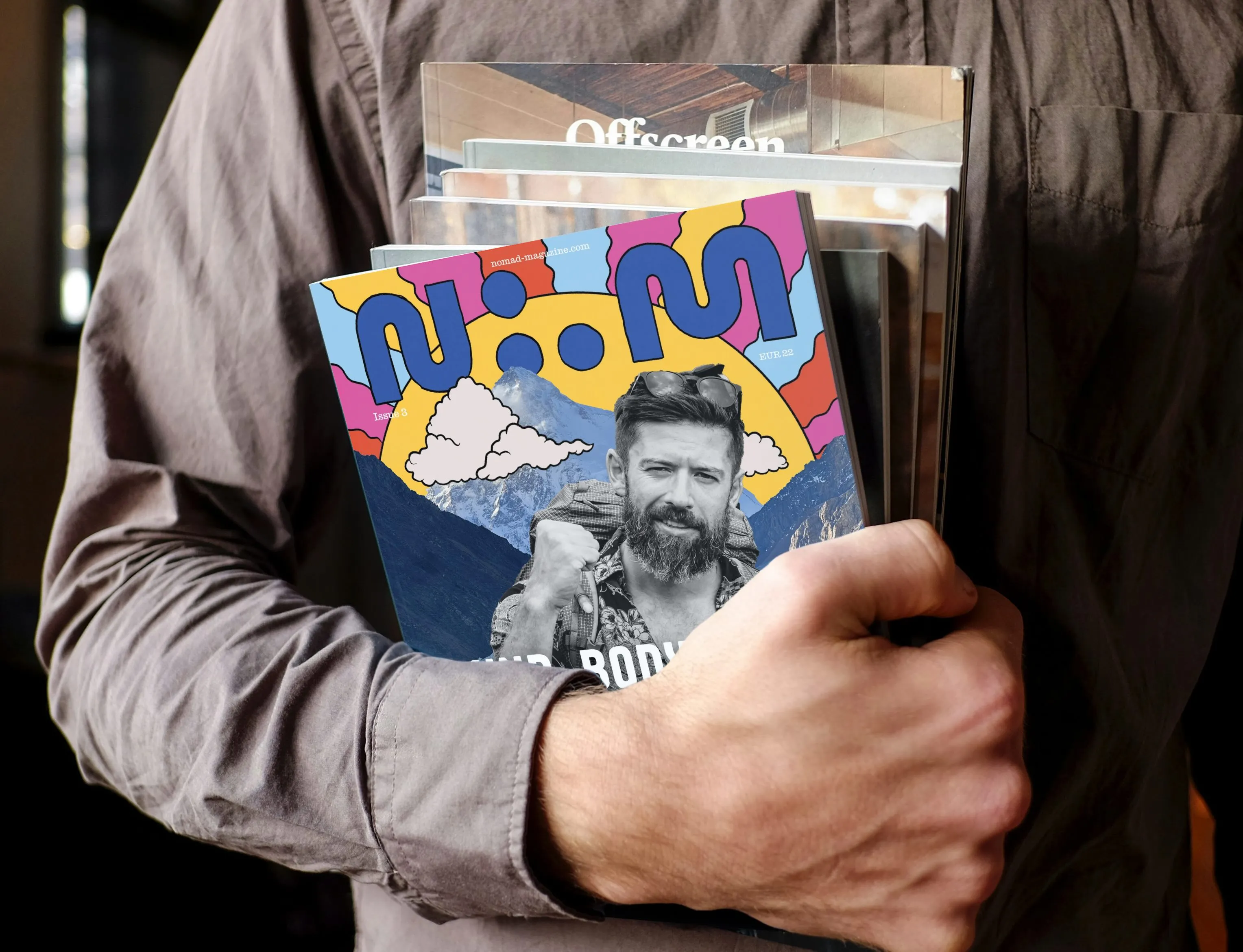 Person holding Nomad Magazine in coworking space